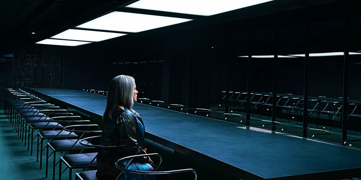 Ms Cobel sits in a conference room alone at Lumon at night in Severance season 2
