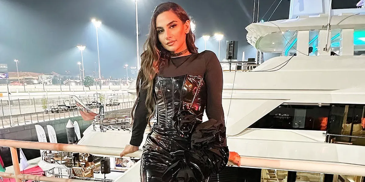 Dubai Bling season 3 Danya Mohammed in a black outfit leaning on a barrier with a yacht visible in the background