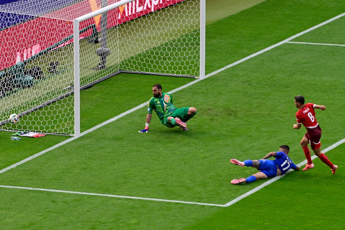 Switzerland's midfielder #08 Remo Freuler (R) kicks the ball to score his team's first goal against Italy's goalkeeper #01 Gianluigi Donnarumma (L) during the UEFA Euro 2024 round of 16 football match between Switzerland and Italy at the Olympiastadion Berlin in Berlin on June 29, 2024. (Photo by JOHN MACDOUGALL / AFP) (Photo by JOHN MACDOUGALL/AFP via Getty Images)