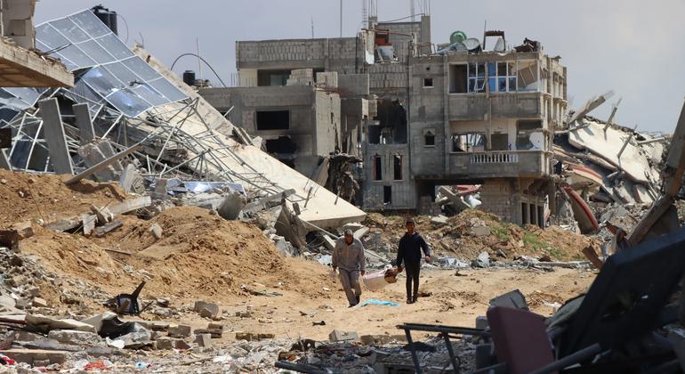 Two people walk thorough the destruction in Khan Younis. Two people walk thorough the destruction in Khan Younis.