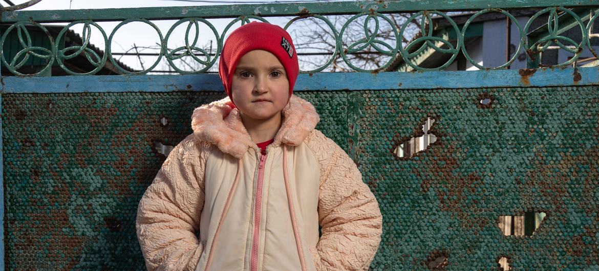 Alina, 12, stands next to her damaged home in Kobzartsi, Mykolaiv region. Alina, 12, stands next to her damaged home in Kobzartsi, Mykolaiv region.