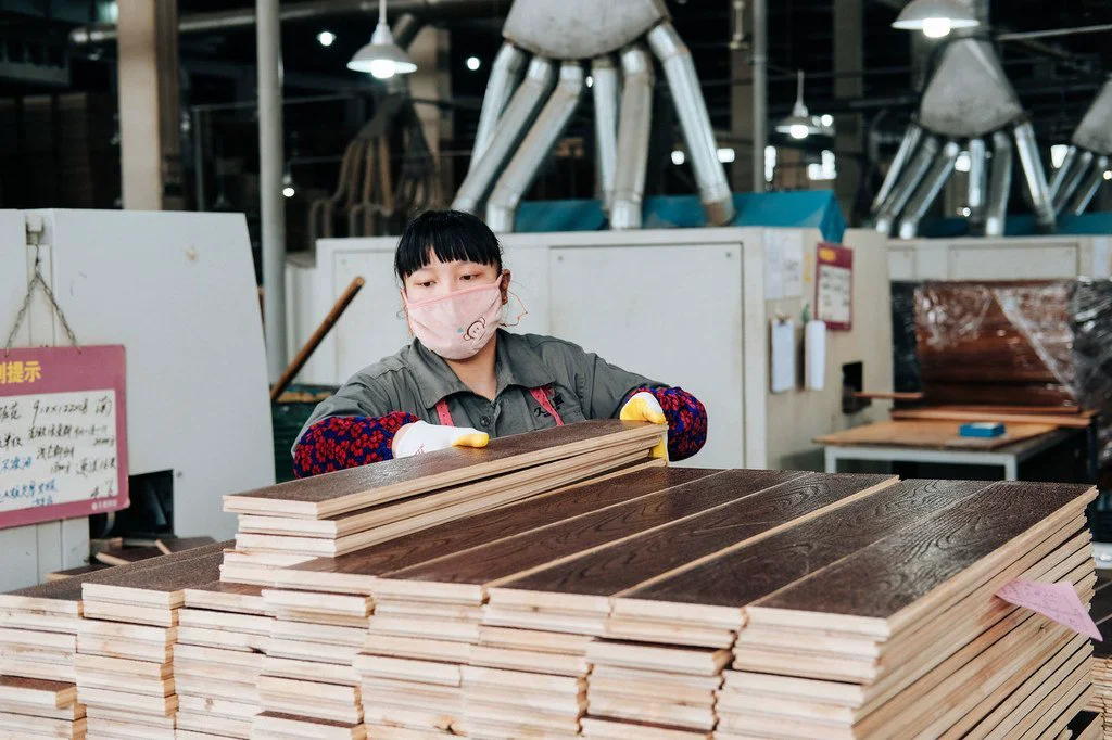 A worker at a factory in Zhejiang, China prepares wood for export.