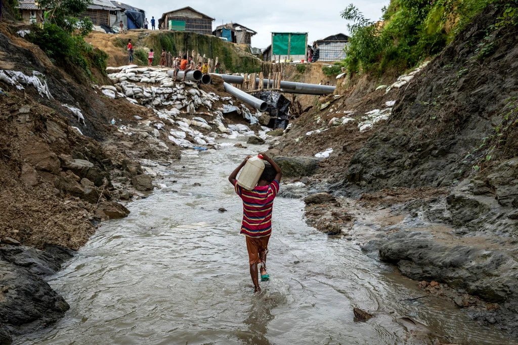 A boy carries water in a refugee camp in Cox's Bazar, Bangladesh.