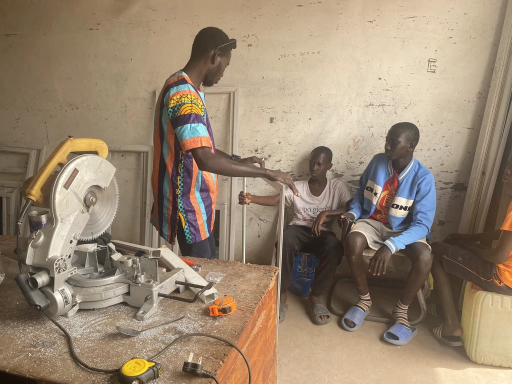 Amadou Jobe, a returning migrant, trains apprentices in a workshop in Banjul, The Gambia.