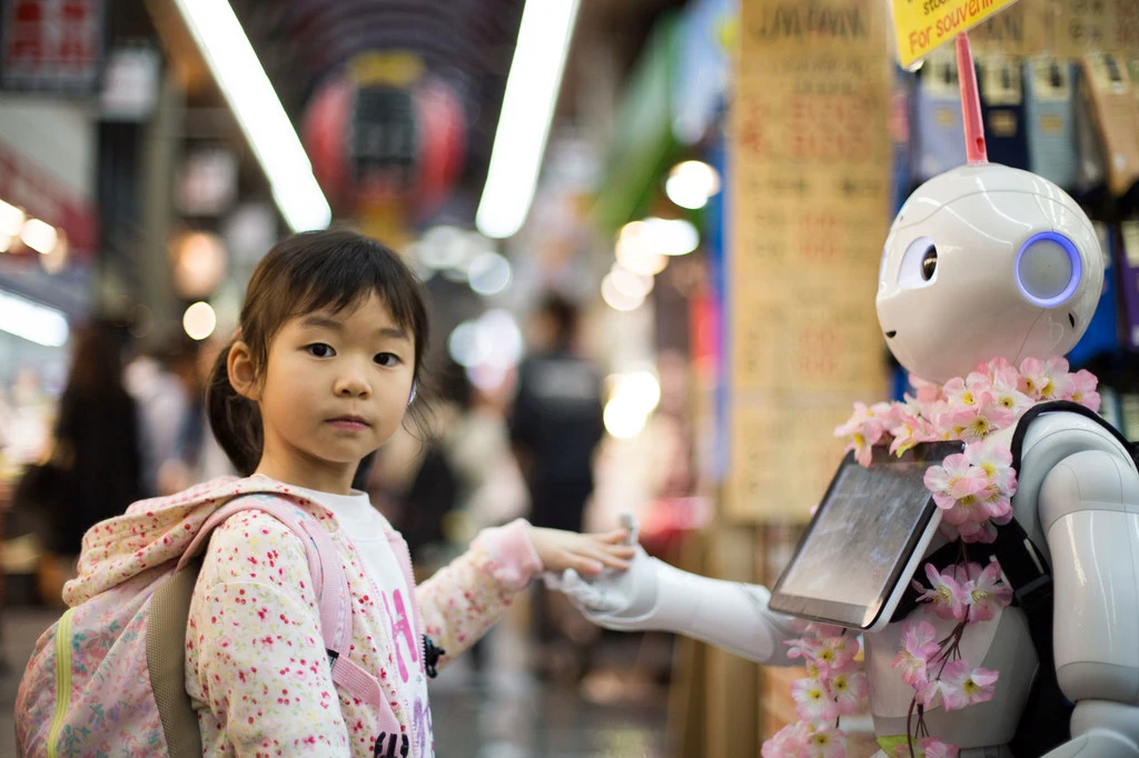 A girl interacts with a robot in Osaka, Japan. A girl interacts with a robot in Osaka, Japan.