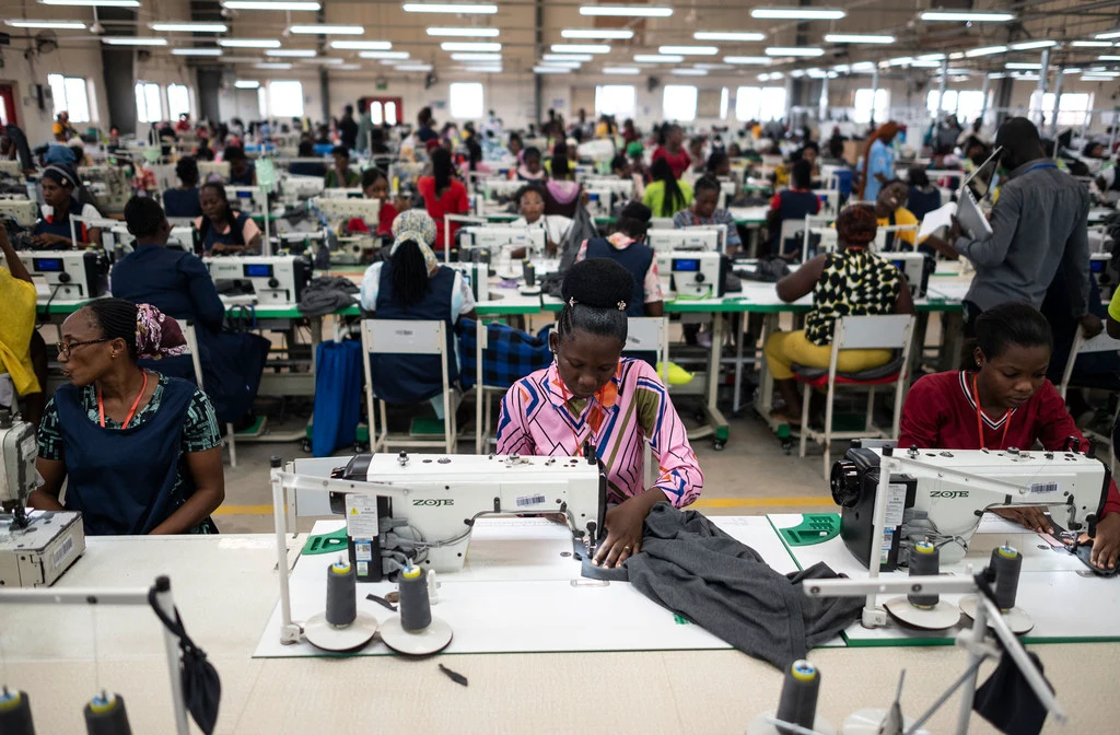 Workers sew fabric at an apparel factory in Ghana. Workers sew fabric at an apparel factory in Ghana.