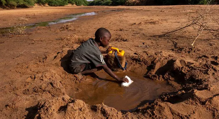 A young boy collects what little water he can from a dried up river due to severe drought in Dollow, Somalia.