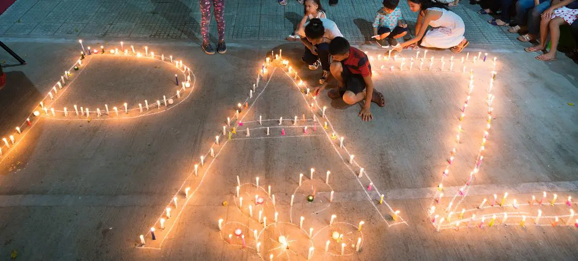 Women and children from the Mocoa community in Colombia light candles forming the word peace. Women and children from the Mocoa community in Colombia light candles forming the word peace.
