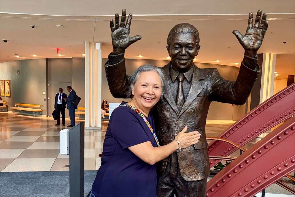 Brenda Reynolds, a recipient of the 2025 United Nations Nelson Rolihlahla Mandela Prize, poses with a statue of the late South African President at UN Headquarters in New York.