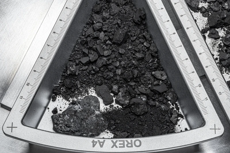 A tray containing a sample from the asteroid Bennu. Researchers say that, based on its size and carbon content, the chemical compounds from such an asteroid could make a “tasty treat.” Credit: Erika Blumenfeld & Joseph Aebers/JSC/NASA