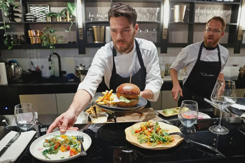 A chef serves burgers made with "cultured chicken" meat at a restaurant. Credit: AFP