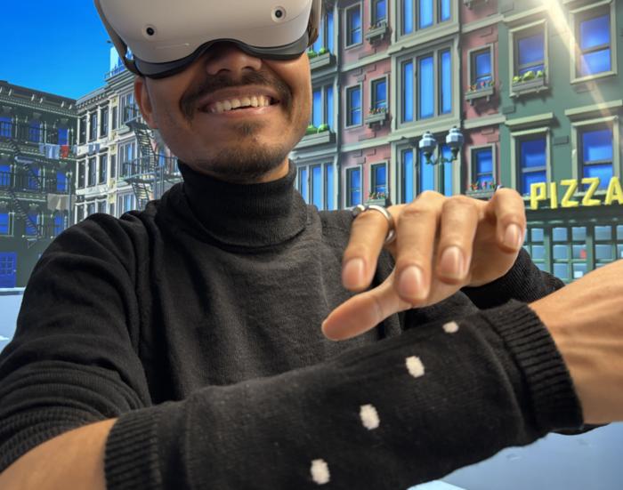 Seamless navigation in a virtual reality environment using a knitted sleeve with overbraided magnetic field sensors and a magnetic ring.