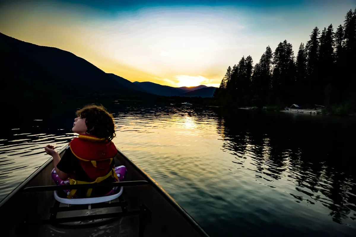 Girl in a canoe at sunset on Priest Lake.