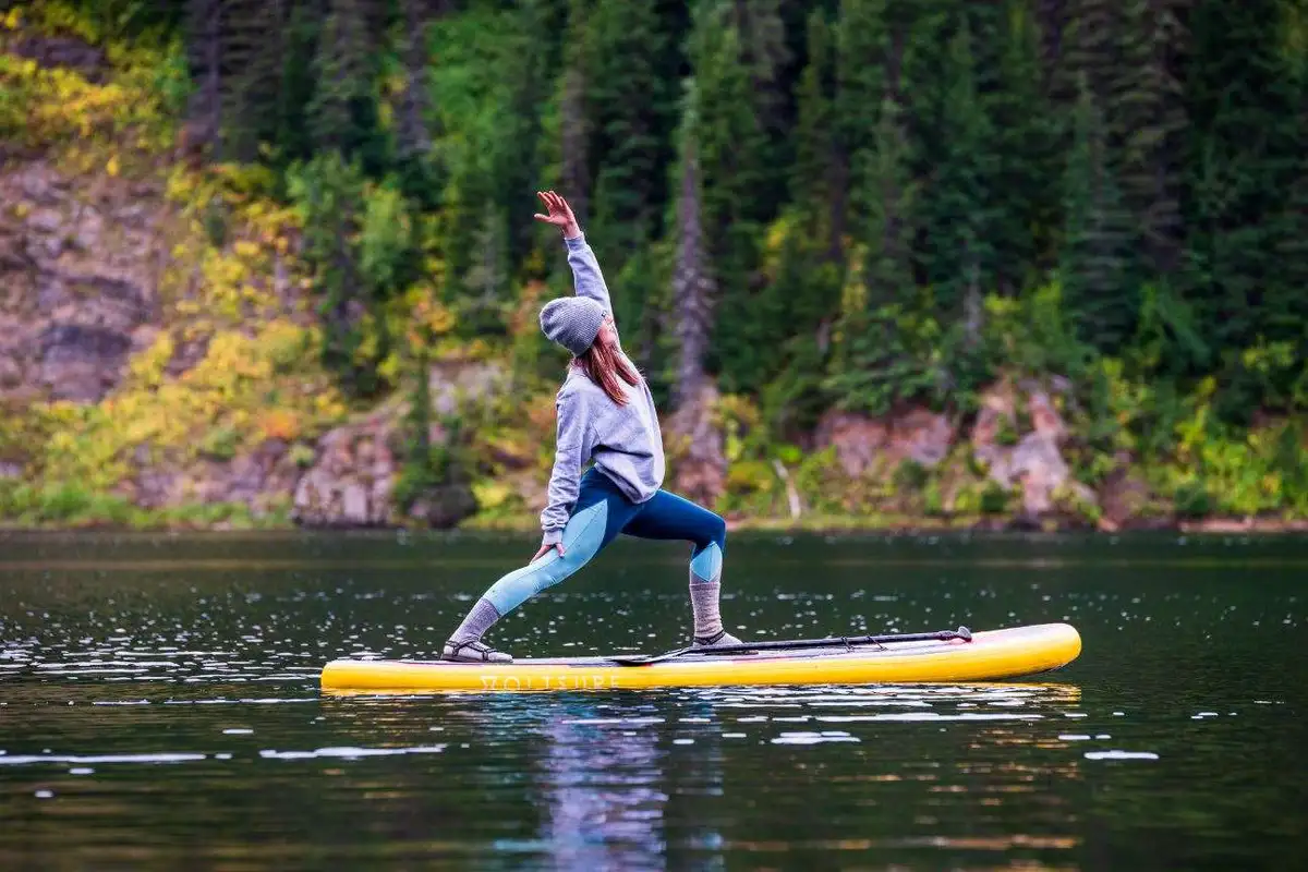 A woman doing yoga while on a paddle board.
