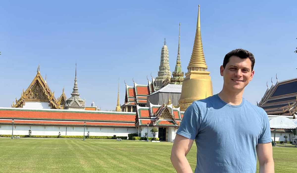Nomadic Matt standing in front of a temple in Bangkok, Thailand