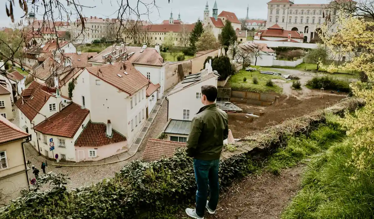 Nomadic Matt looking out over the city of Prague on a cloudy day
