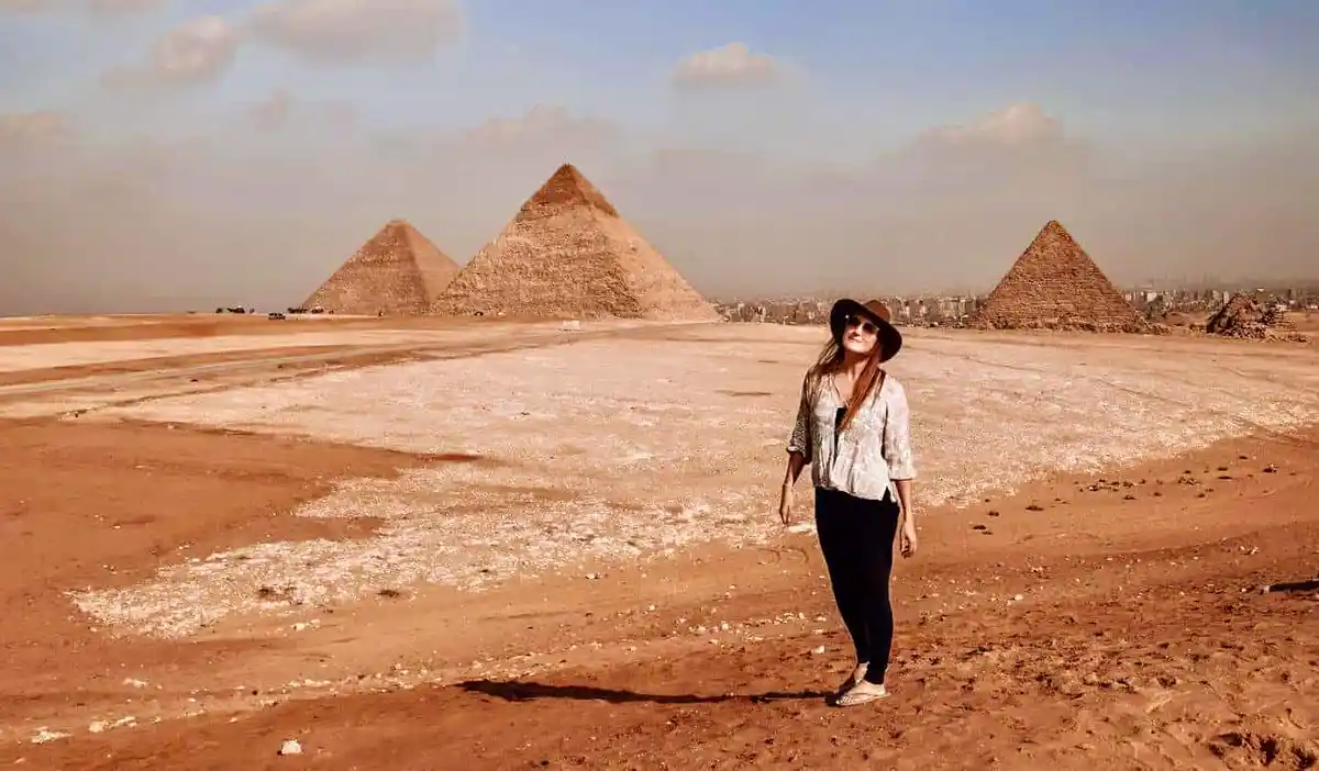 Monica, a solo female traveler, posing near the pyramids in Egypt