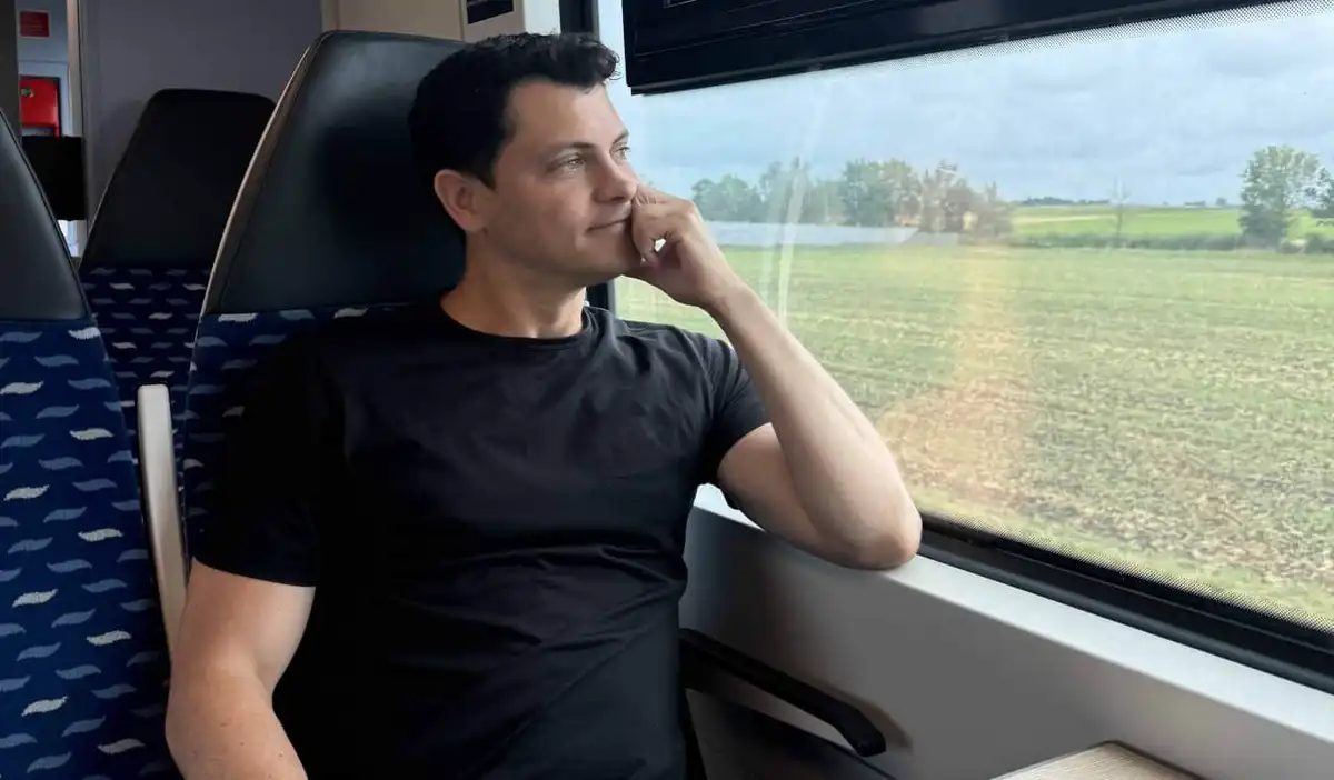Nomadic Matt looking out the window on a train