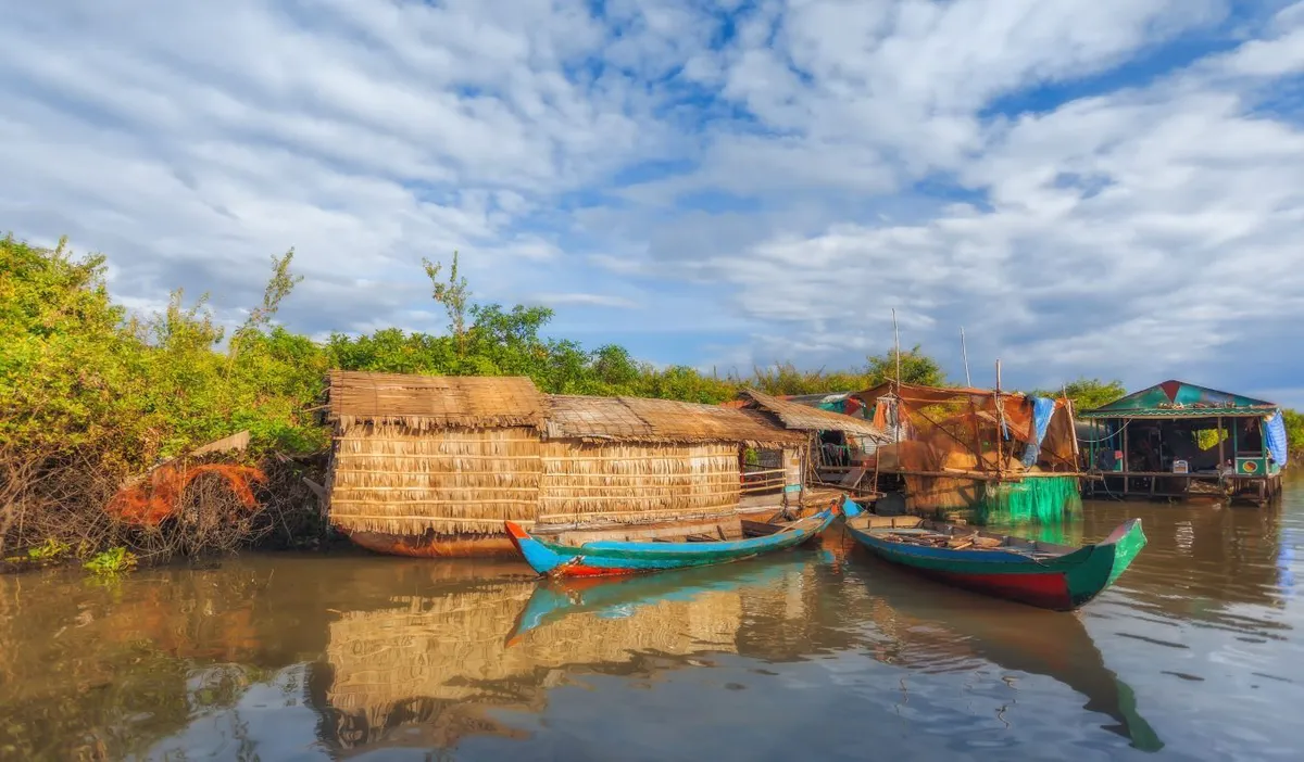 Floating huts on the water surrounded by small boats at Tonle Sap in Cambodia