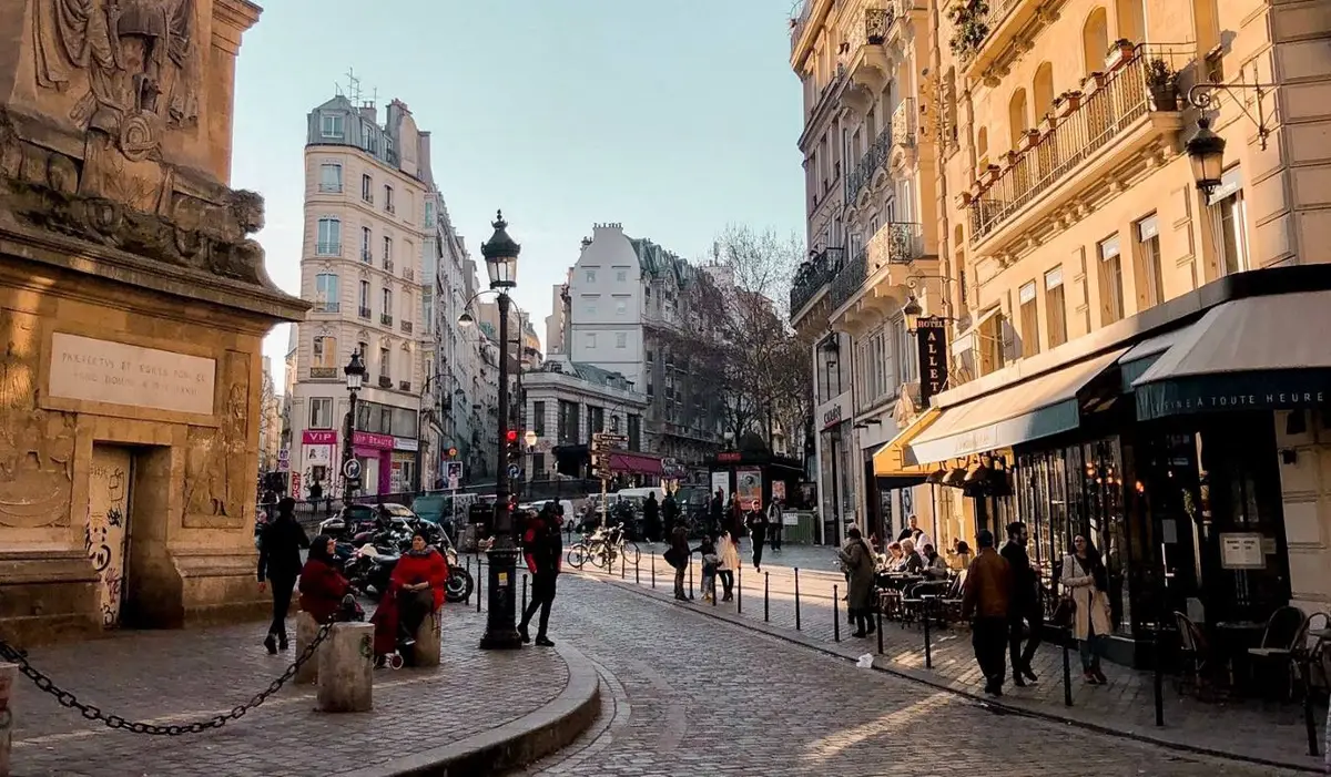 A winding street in Paris with golden light shining on the buildings
