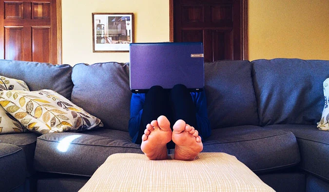 a person sitting on the couch with a laptop