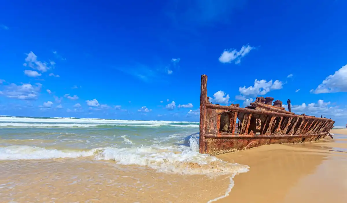 The famous shipwreck on the beach of Fraser Island in Australia with a bright blue sky above