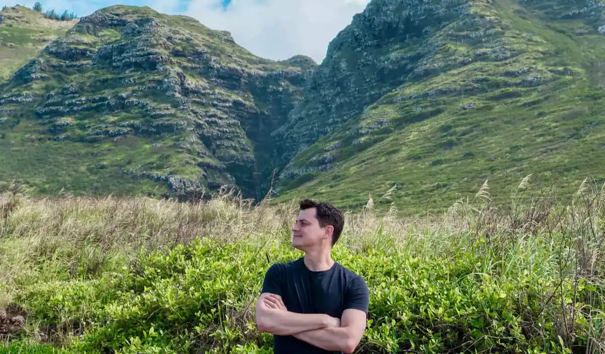 Nomaidc Matt posing for a photo in the rugged hills of sunny Hawaii