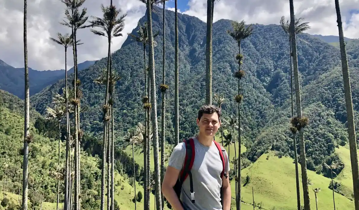 Nomadic Matt posing near a beautiful, lush mountain in rural Colombia